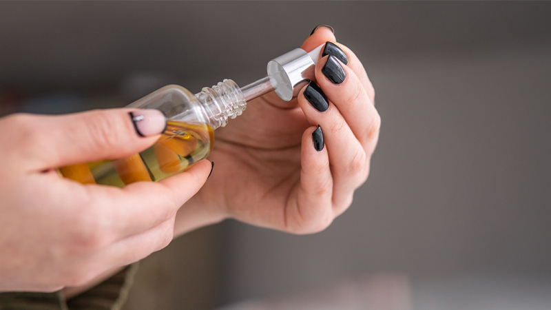 Woman holding CBD oil with a dropper